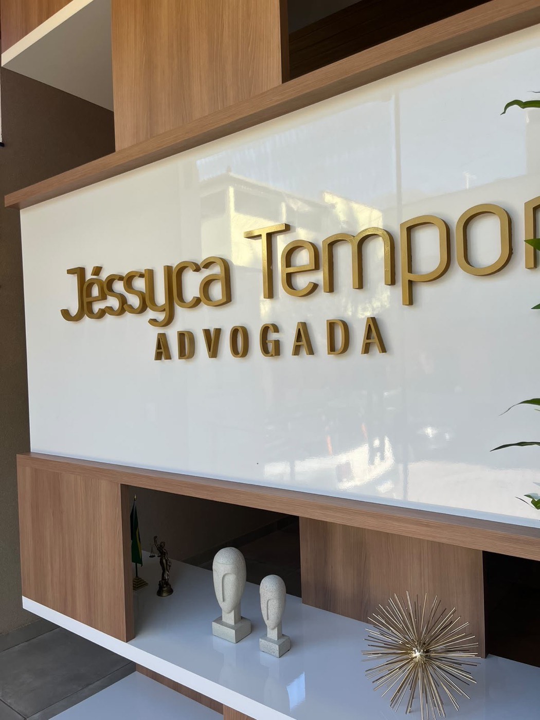 Letras douradas da Jéssyca Temponi Advocacia no painel da recepção
