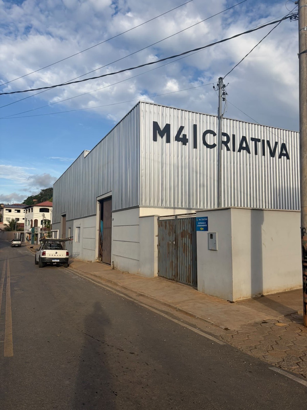 Galpão da M4 Criativa em Divinolândia de Minas, com o letreiro M4 Criativa na fachada metálica